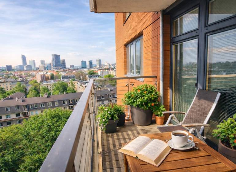 A balcony with a view of the panorama of Bratislava from a 2-room apartment with a wooden decor floor.