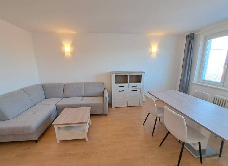 Living room in a 4-room apartment with a corner sofa and a dining table.