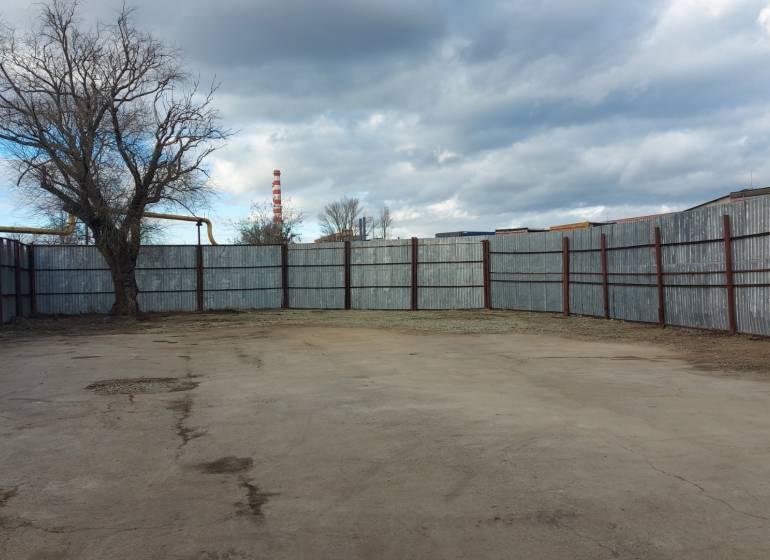 A fenced plot with a concrete surface in Košice, Juh district, suitable for commercial use.