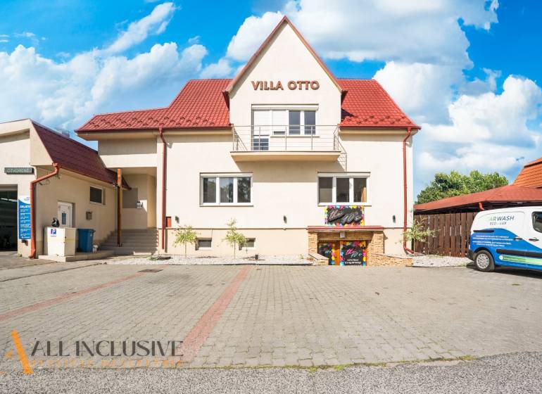 A building with a red roof and designated parking in Dunajská Streda.