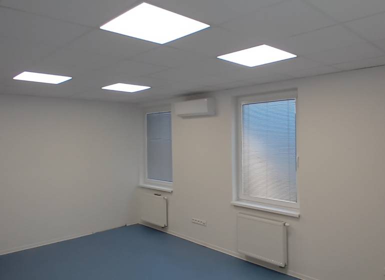 Offices with a white ceiling, blue floor, and windows with blinds.