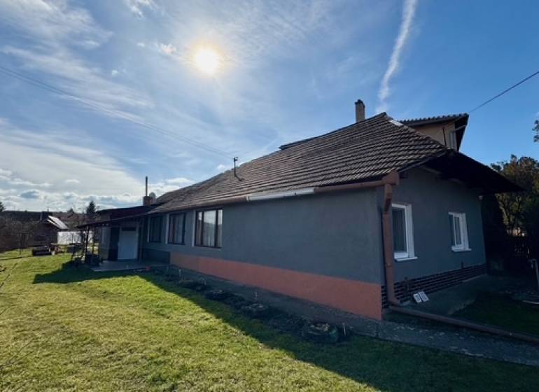 A family house in Mýtne Ludany with a grassy garden and a brick facade.