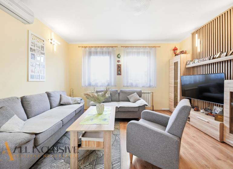 Living room in a family house with a comfortable gray sofa and a wooden decor floor.
