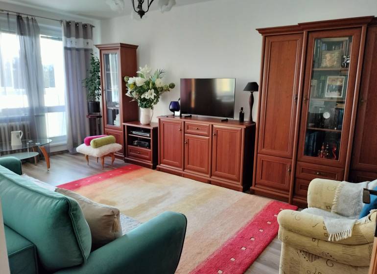 Living room in a two-room apartment with a wooden decor floor and comfortable furniture.