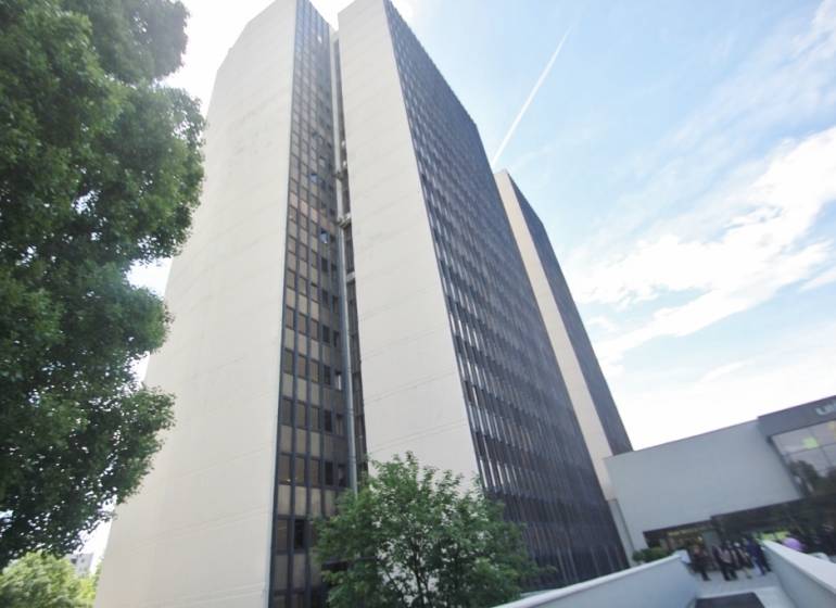 High-rise office building on Kutlíkova Street in Bratislava - Lúky, partially surrounded by greenery.