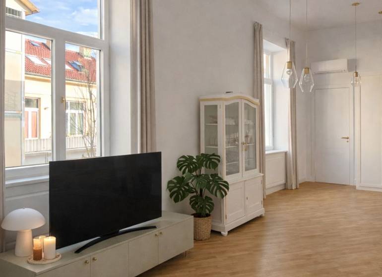 Living room in a 3-room apartment with wood-patterned flooring, a television, and large windows.