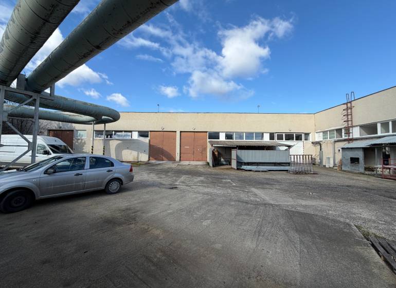 Warehouses and halls in Nové Zámky on the street Nové Zámky with an industrial complex and cars.