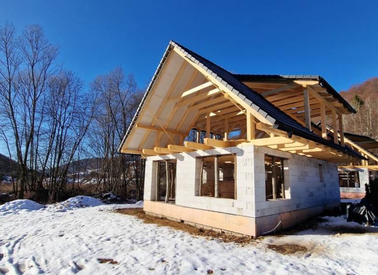 An unfinished cottage with a wooden roof during winter in Mýto pod Ďumbierom.
