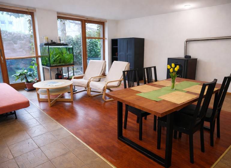 Living room in a three-room apartment with a wooden decor floor, a dining table, and an aquarium.