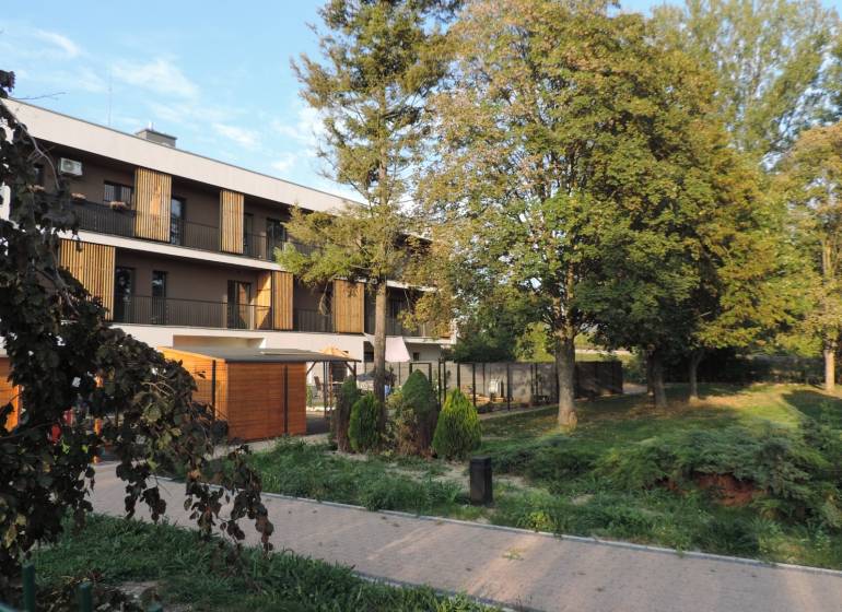 An apartment building on Bodona Street, surrounded by greenery and trees, ideal for studio living.