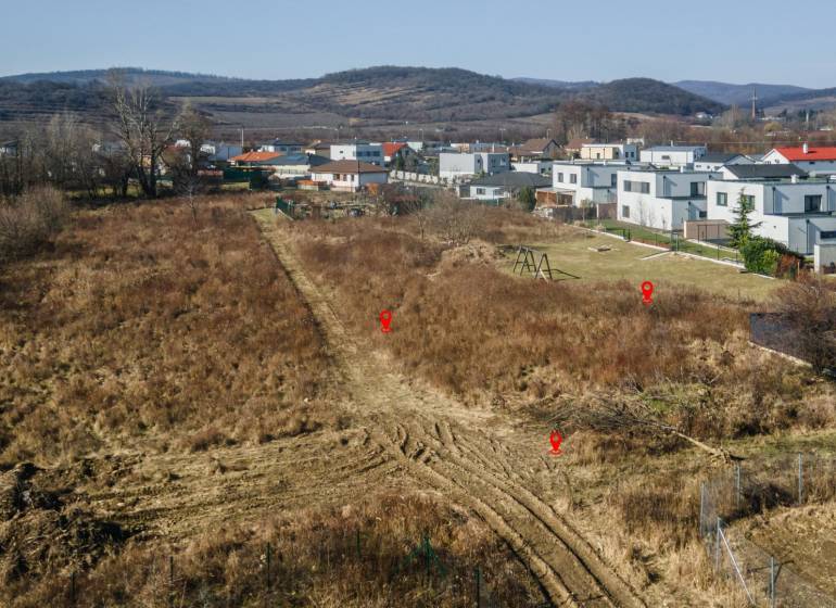 Land for residential use in Pezinok, surrounding houses, natural scenery, hills in the background.