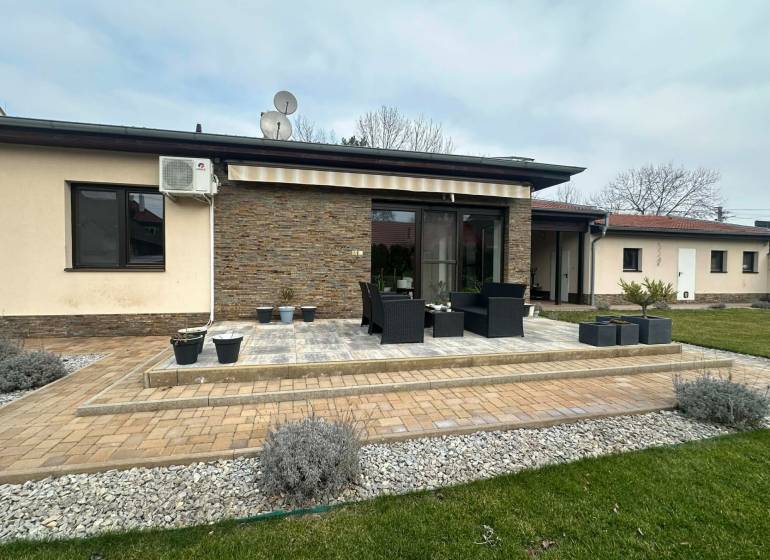 Terrace of a family house in Komárno with flower pots and outdoor seating.