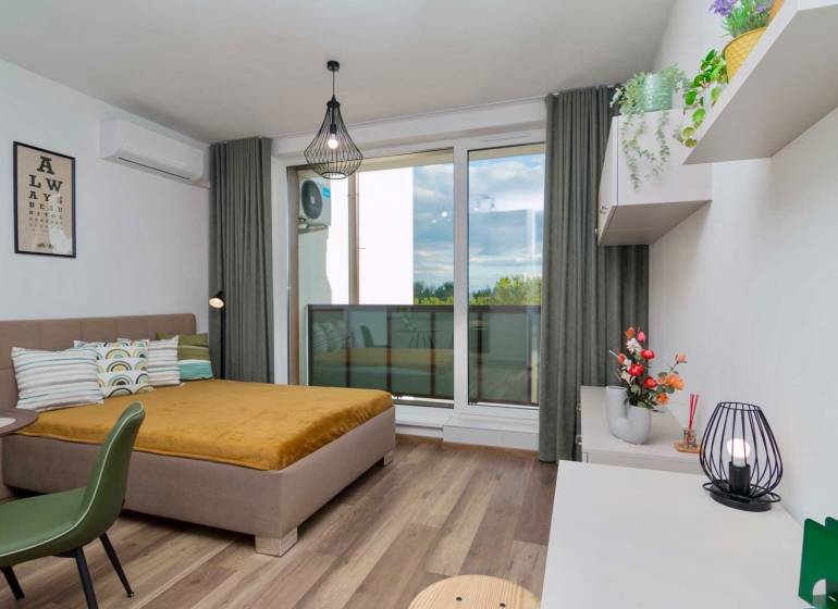 1-bedroom apartment with wood-patterned flooring, modern lighting, and a view of the terrace.