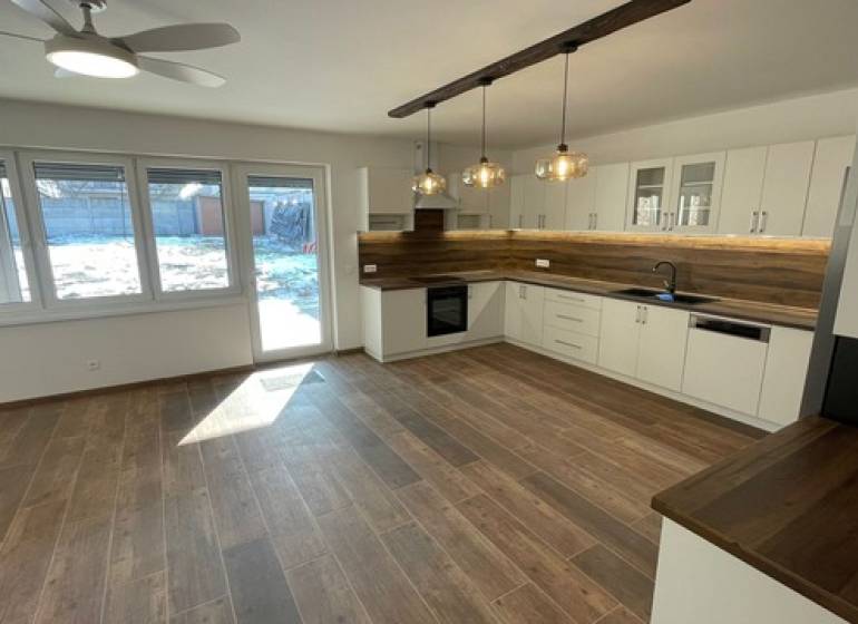A kitchen in a family house with wooden floor decor and modern lighting.