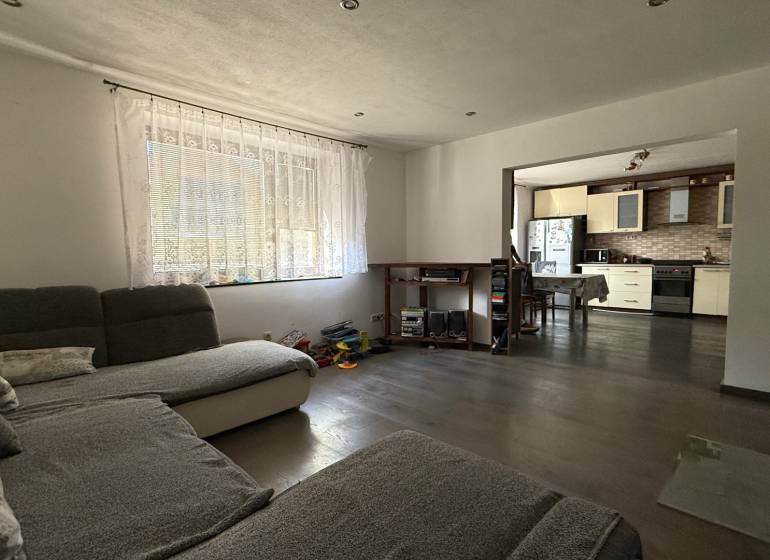 Living room in a family house with a view of the kitchen, floor with wood decor.