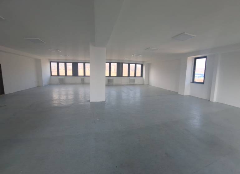Spacious commercial spaces with large windows and light flooring.