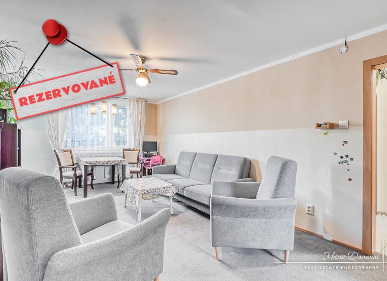 Living room in a 4-room apartment with comfortable armchairs and a dining area.
