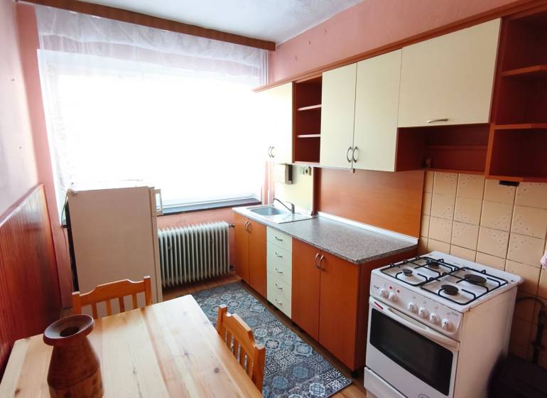 A kitchen in a family house with a wooden floor decor, a gas stove, a dining table.