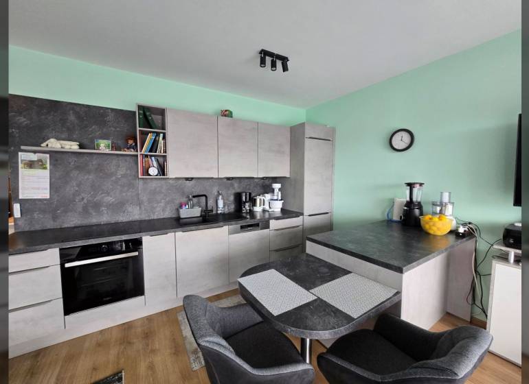 A kitchen with a dining table and a wooden decor floor in a Holiday Apartment.