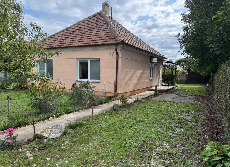 Family house in Komárno with a grassy garden and trees on a landscaped plot.