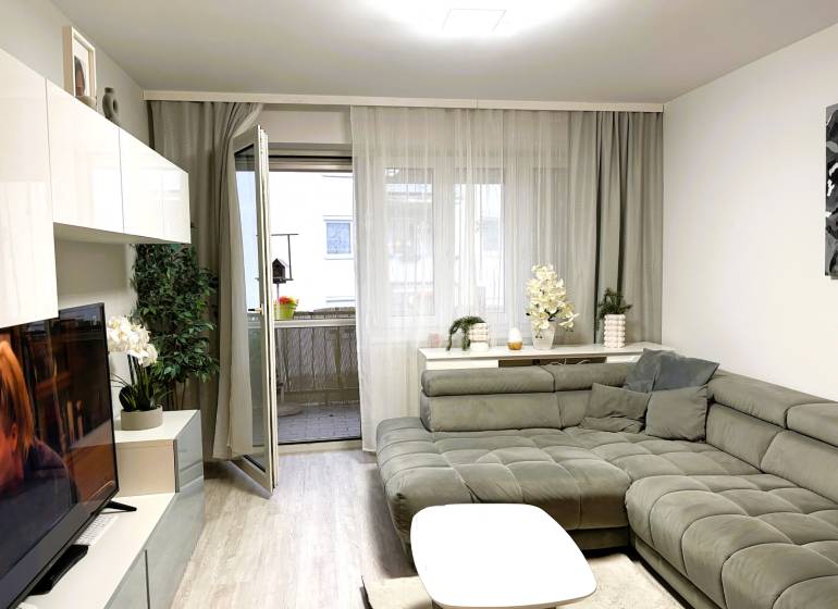 Living room in a 3-room apartment with a comfortable sofa corner and a wooden decor floor.