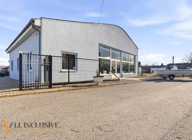 Commercial premises in Štúrovo with a gray facade, parking, and a shelter.