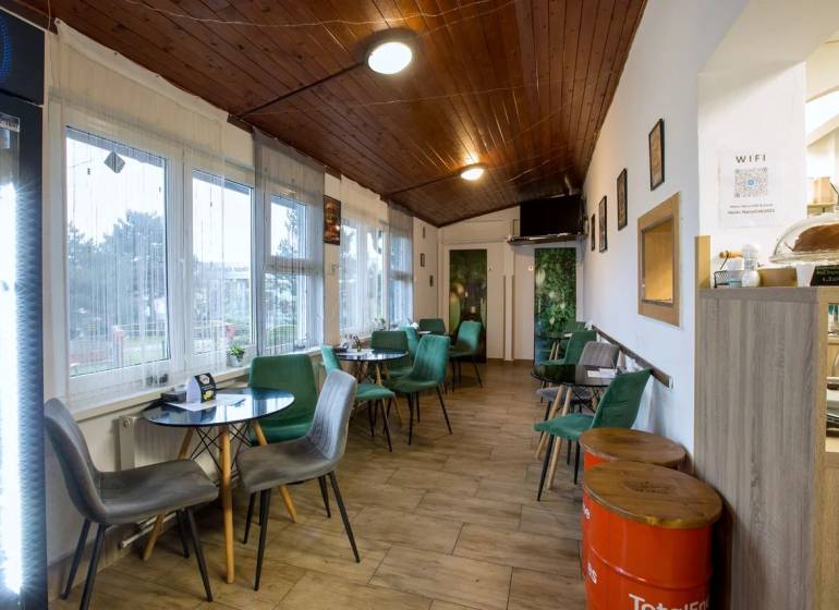 Gastro premises with chairs, tables, and flooring with a wooden decor.