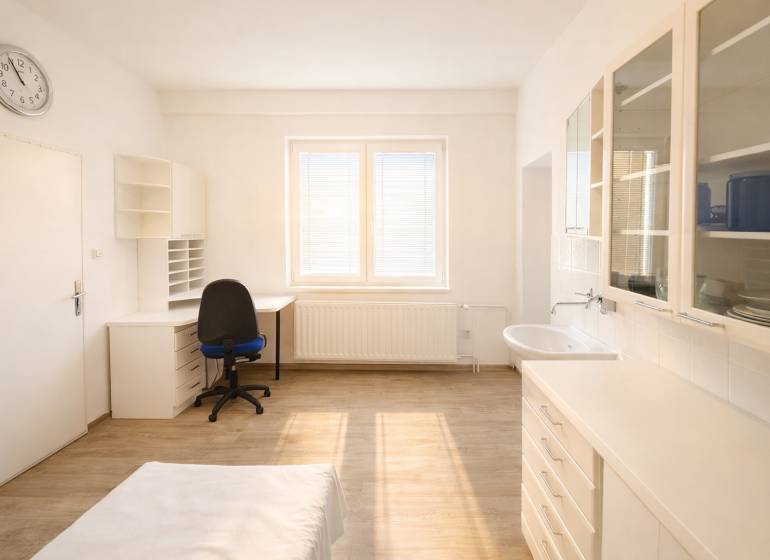 Offices with wood-patterned flooring, a desk, a sink, and cabinets.