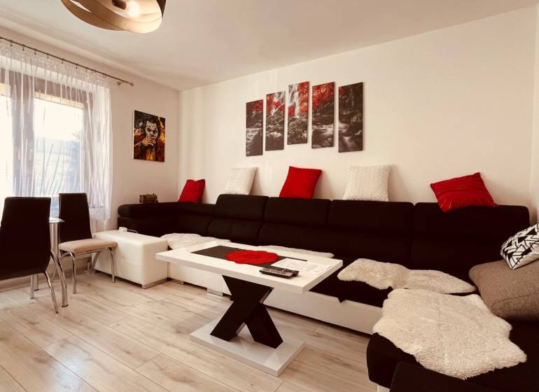 Living room in a three-room apartment, with a sofa and a wooden decor floor.