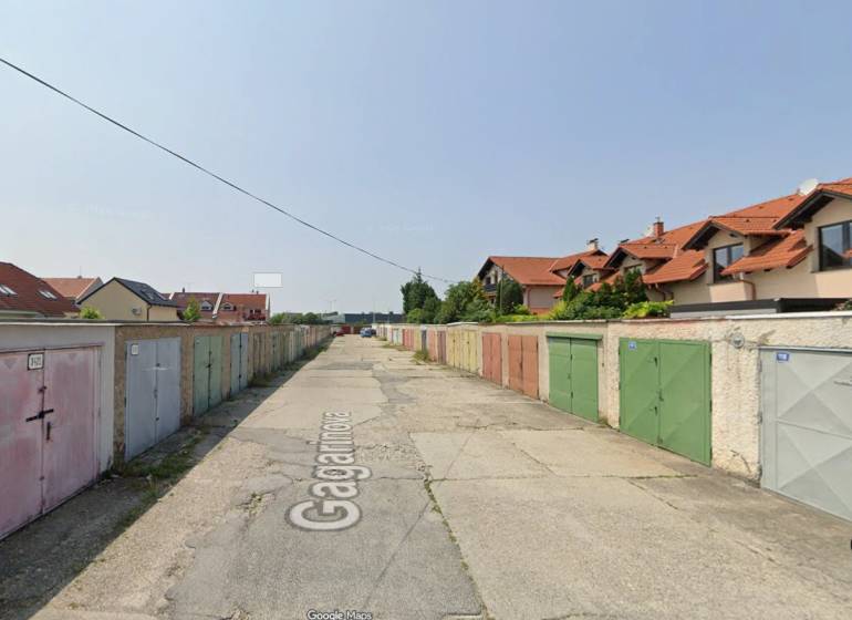 Garages on Gagarin Street in Senec with neighboring houses and planted vegetation.