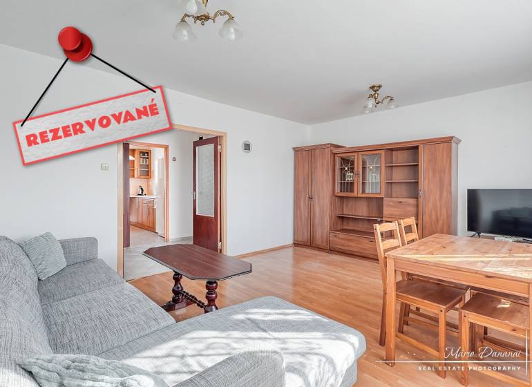 Living room in a three-room apartment with a wooden decor floor and a comfortable sofa.
