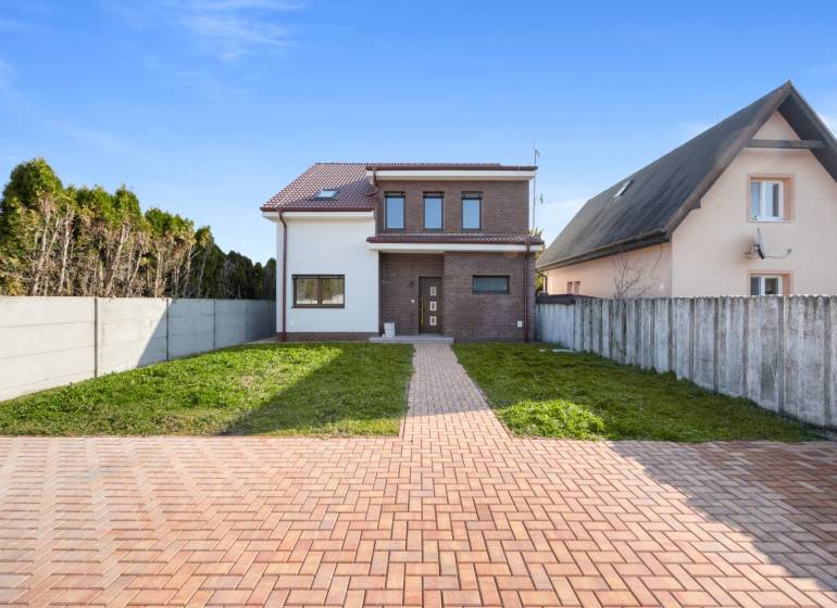 A family house in Vojka nad Dunajom with brick cladding and a garden.