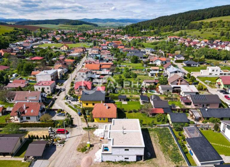 An aerial view of the residential development of family houses in Harichovce, surrounded by greenery and hills.