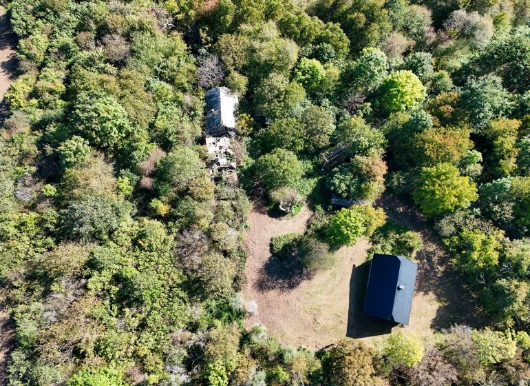 Aerial view of agricultural and forest land in Lackov, surrounded by dense forests and buildings.