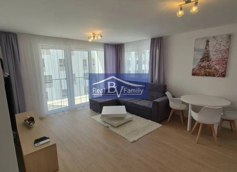 Living room in a two-room apartment with a wooden decor floor and comfortable seating.