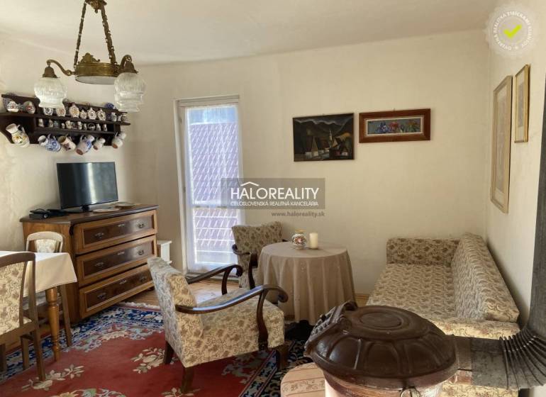 Living room in a family house with retro furniture, a sofa, and a tiled stove.
