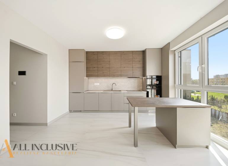 A kitchen in a 2-room apartment with a wooden decor floor and large windows.