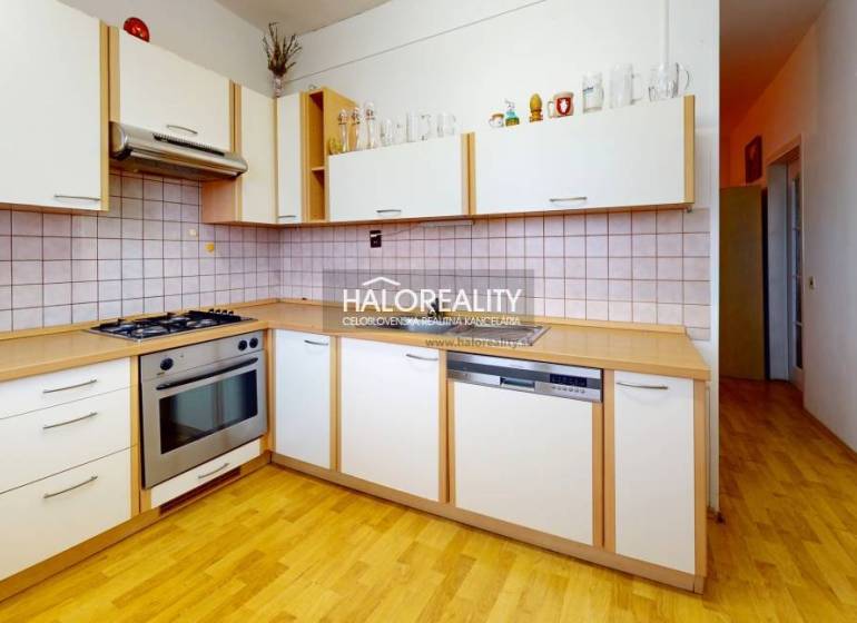 A kitchen in a 3-room apartment with a wood-patterned floor and built-in appliances.