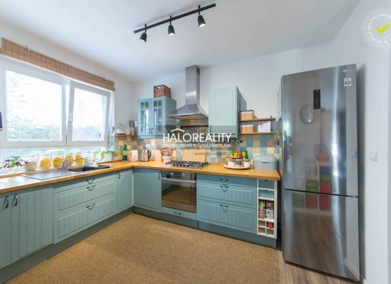 A spacious kitchen with light blue cabinets and stainless steel appliances in a 3-room apartment.