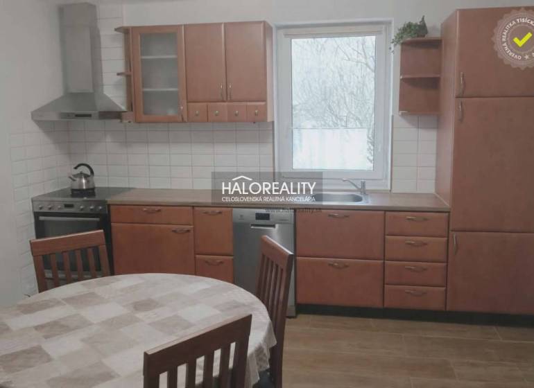 A kitchen in a family house with wooden decor, a dining table, a kitchen unit, a window.