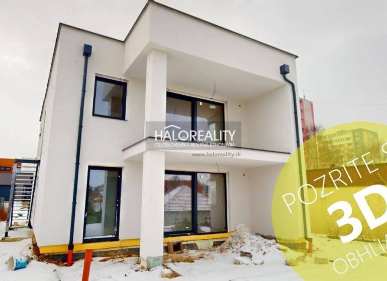 A modern two-story building with balconies in the snowy streets of Poprad, ideal for offices.