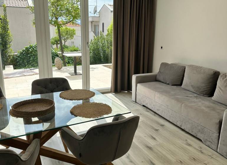Recreational apartment with wood-patterned flooring, glass table, and sofa.