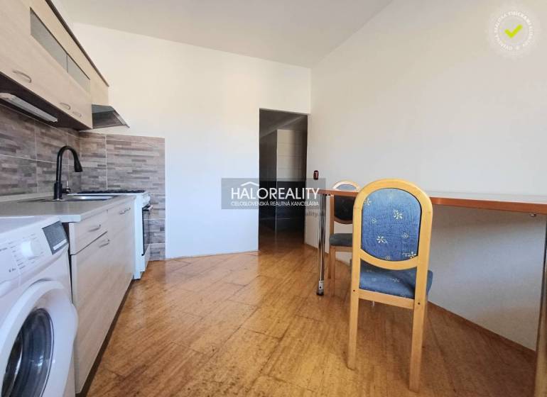 A kitchen in a 3-room apartment with a wooden decor floor and a dining table.