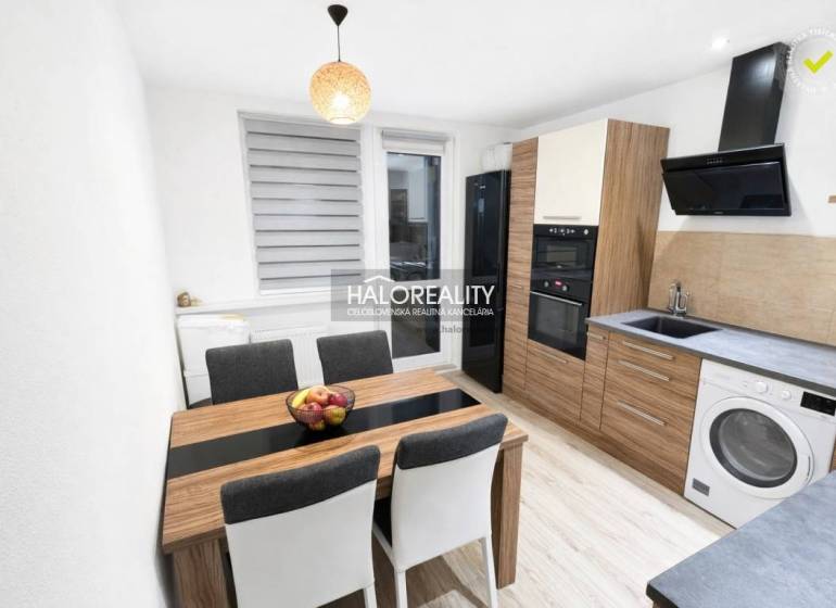 A kitchen in a 3-room apartment with a wooden decor floor and modern furnishings.