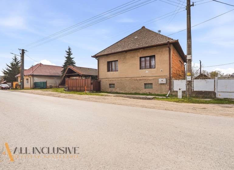 A family house in Malá nad Hronom with a brown facade and electric poles.