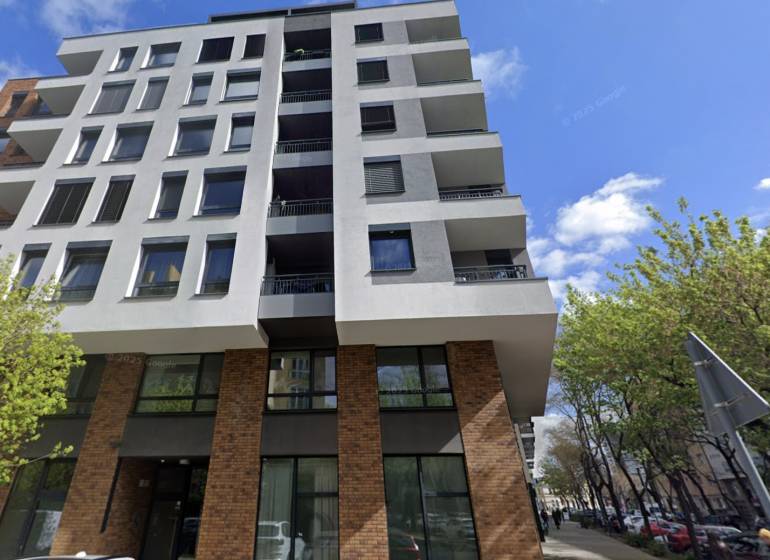 A five-story building on Bernolákova Street in Bratislava - Staré Mesto surrounded by trees.