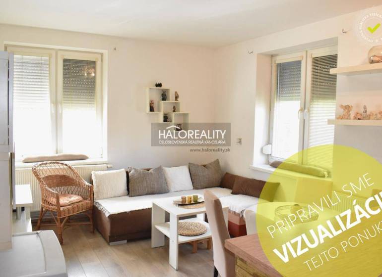 A bright living room with a sofa and a wood-patterned floor in a two-room apartment.