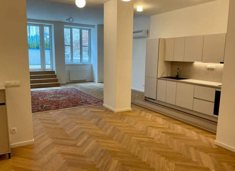 A kitchen corner with a wooden decor floor and stairs in a 2-room apartment.