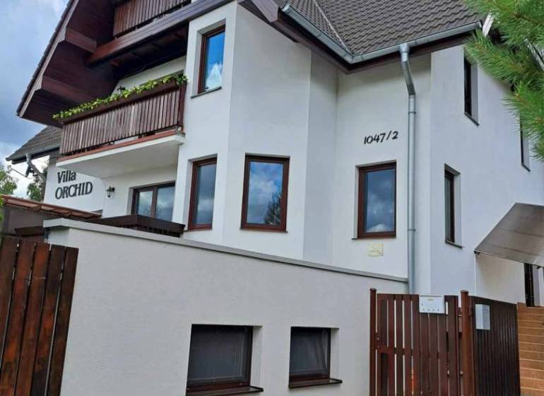 A villa with wooden balconies and a brown roof in Veľká Lomnica.