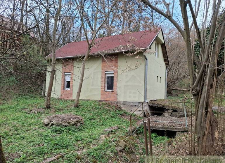 A cottage in Chľaba surrounded by trees and nature.